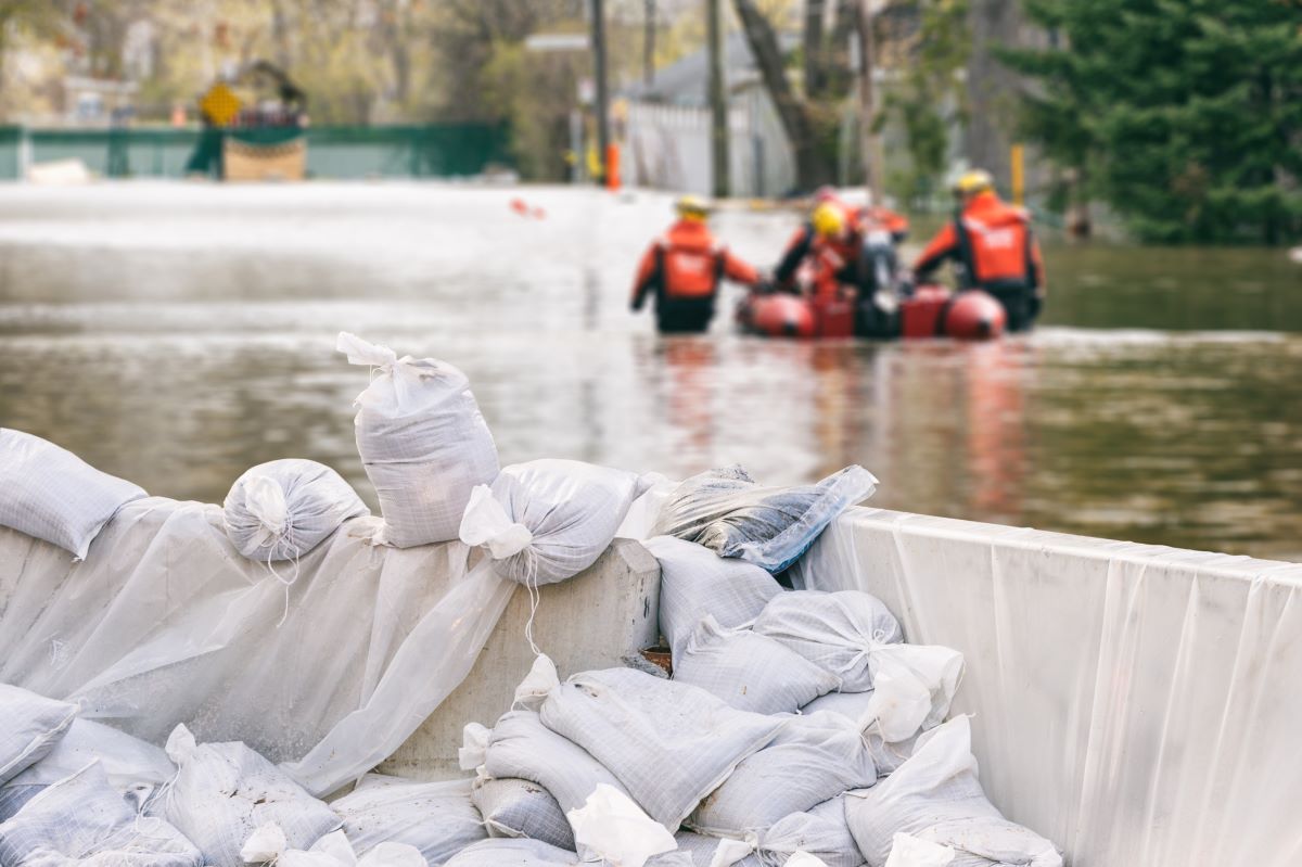 flood protection sandbags with flooded homes in the background